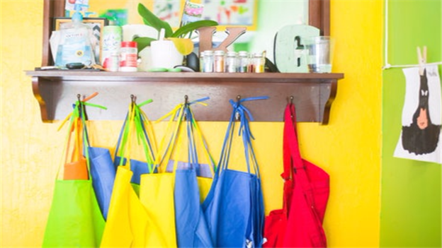 children's coloured painting aprons hanging on pegs